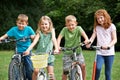 Group Of Children Playing On Bikes And Scooter