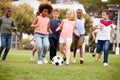 Group Of Children Playing Football With Friends In Park Royalty Free Stock Photo