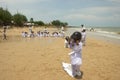 A group of children playing a sack race with helmet on (balap karung dengan helm), in Tlangoh beach.