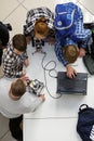 Group of children programming the robot at robotics competitions.
