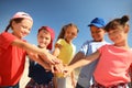 Group of children putting hands together outdoors on sunny day. Summer camp Royalty Free Stock Photo