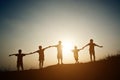 Group of children silhouettes holding hands together. Royalty Free Stock Photo