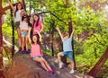 Group of kids cheering standing on stone in forest Royalty Free Stock Photo