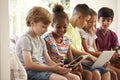 Group Of Children Sit On Window Seat And Use Technology Royalty Free Stock Photo