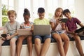 Group Of Children Sit On Window Seat And Use Technology Royalty Free Stock Photo