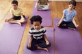 Group Of Children Sitting On Exercise Mats And Meditating In Yoga Studio Royalty Free Stock Photo