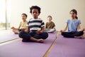 Group Of Children Sitting On Exercise Mats And Meditating In Yoga Studio Royalty Free Stock Photo