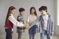 Group of children stand and join hands together studio shot on copy space Royalty Free Stock Photo