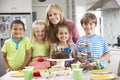 Group Of Children Standing With Mother By Table Laid With Birthday Party Food Royalty Free Stock Photo