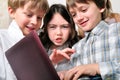 Group of children studying at laptop