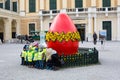 The group of children taking photo in front of large red Easter egg