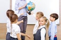 Group of children and teacher holding a globe