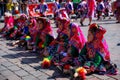 Group of children in traditional Peruvian dresses, sitting on the street