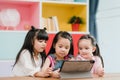 Group of children using tablet in classroom, Multi-ethnic young boys and girls happy using technology for study and play games at Royalty Free Stock Photo