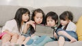 Group of children using tablet in classroom, Multi-ethnic young boys and girls happy using technology for study and play games at Royalty Free Stock Photo