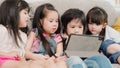 Group of children using tablet in classroom, Multi-ethnic young boys and girls happy using technology for study and play games at Royalty Free Stock Photo