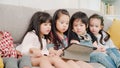 Group of children using tablet in classroom, Multi-ethnic young boys and girls happy using technology for study and play games at Royalty Free Stock Photo