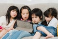 Group of children using tablet in classroom, Multi-ethnic young boys and girls happy using technology for study and play games at Royalty Free Stock Photo