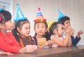 Group of children waiting to blow birthday cake