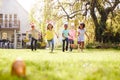 Group Of Children Wearing Bunny Ears Running To Pick Up Chocolate Egg On Easter Egg Hunt In Garden Royalty Free Stock Photo