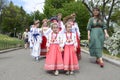 Group of children and women in Ukrainian traditional embroidery costumes walking in the municipal city park