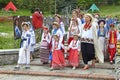 Group of children and women in Ukrainian traditional embroidery costumes walking in the municipal city park