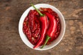 Group of chilli peppers and dried chilli inside white bowl on wooden table Royalty Free Stock Photo