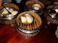 Group of Chinese dumpling in bamboo steamer box on brown wooden table