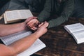 A group of Christians pray holding hands. On the table. The Holy Bible is open. Praying Royalty Free Stock Photo