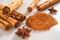 Group of cinnamon sticks with star anice and powder on a white and lucid backround Royalty Free Stock Photo