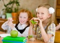 Group of classmates having lunch during break with focus on smiling girl with sandwich Royalty Free Stock Photo