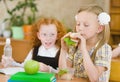 Group of classmates having lunch during break with focus on smiling girl with sandwich Royalty Free Stock Photo