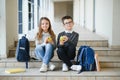 Group of classmates having lunch during break with focus on smiling girl with apple. Royalty Free Stock Photo