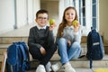 Group of classmates having lunch during break with focus on smiling girl with apple. Royalty Free Stock Photo