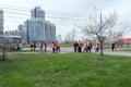 Group of cleaners of bright orange protective vests are sweeping the city sidewalk on a spring street in a residential area