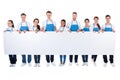 Group of cleaners holding a blank white banner Royalty Free Stock Photo