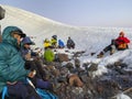 Group of climbers with backpacks and trekking poles on a halt