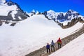Group of climbers looking at snow-capped mountains and glacier