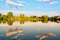 A group of clouds in the sky is reflected in the water of the lake