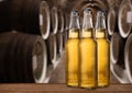 Group of cold wet beer bottles in the cellar with vintage kegs Royalty Free Stock Photo