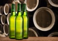 Group of cold wet beer bottles in the cellar with vintage kegs Royalty Free Stock Photo