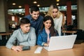 Group of college students studying in the school library, a girl and a boy are using a laptop and connecting to internet Royalty Free Stock Photo