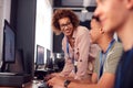 Group Of College Students With Tutor Studying Computer Design Sitting At Monitors In Classroom Royalty Free Stock Photo