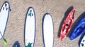 Group of color boards for stand up paddle surfing or SUP lying on beach at sea waves background at summer day Royalty Free Stock Photo