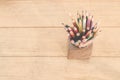 Group of color pencils in a wood cup .