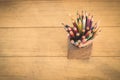 Group of color pencils in a wood cup .