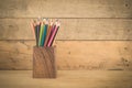 Group of color pencils in a wood cup .