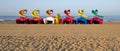 Group of colored pedal boats with slide parked on the beach waiting to be rented