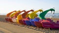 Group of colored pedal boats with slide parked on the beach waiting to be rented