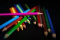 GROUP OF COLORED PENCILS ALIGNED ON BLACK BLACKGROUND Royalty Free Stock Photo